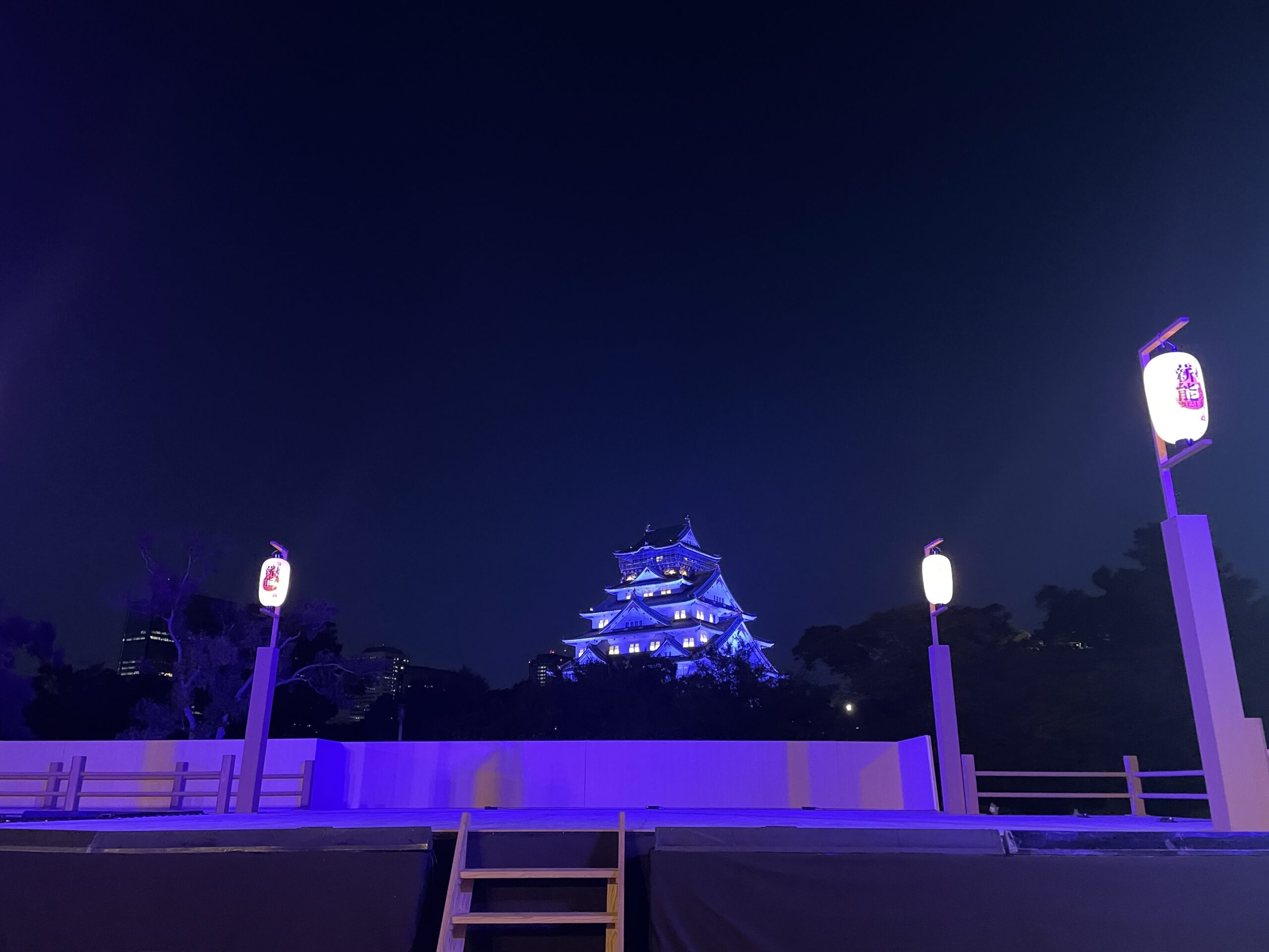 青い光に包まれた舞台と大阪城