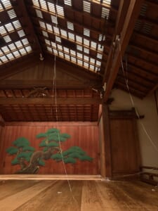 終演後の能舞台に長く垂れる土蜘蛛の糸
